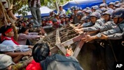 Student protesters struggle with riot police to remove a barricade during a protest against new education law in Letpadan, 140 kilometers (90 miles) north of the country's main city Yangon, Myanmar, March 10, 2015. Police arrested Kyaw Ko Ko, the leader of the student movement after he spent more than six months in hiding, a human rights monitoring group said.