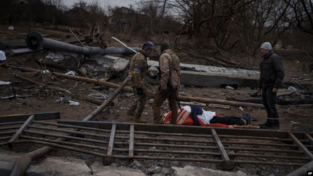 El cuerpo de un civil fallecido yace entre los escombros, en un camino que era usado como un corredor seguro para salir de la localidad de Irpin, en las afueras de Kiev, el 