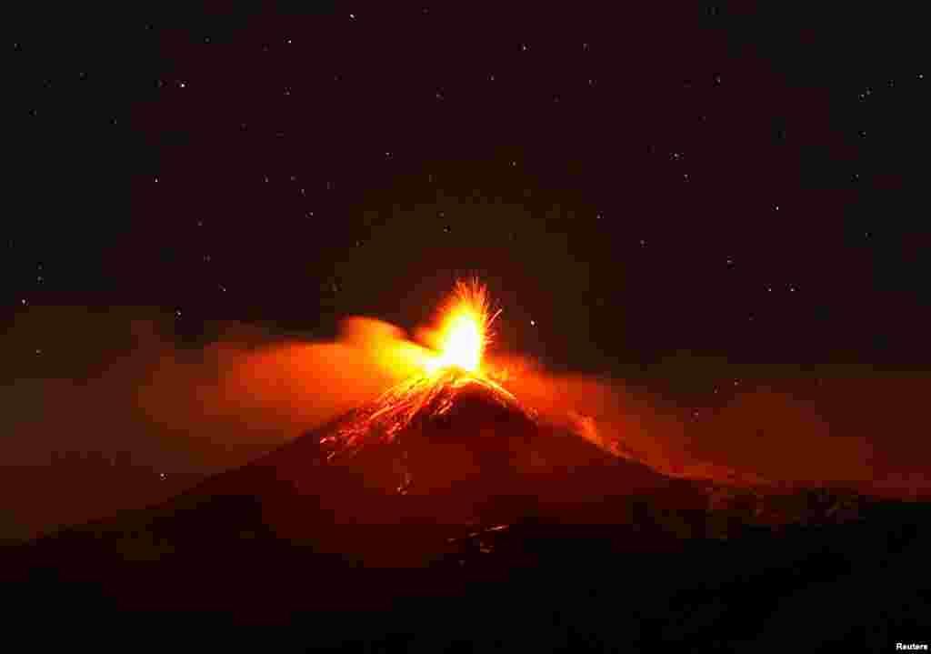 Large streams of red hot lava shoot into the night sky as Mount Etna, Europe&#39;s most active volcano, leaps into action, seen from the village of Fornazzo, Italy, Feb. 3, 2021.