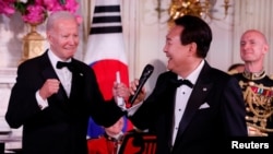 El presidente de Estados Unidos, Joe Biden, reacciona mientras el presidente de Corea del Sur, Yoon Suk Yeol, canta en una cena de Estado, durante la visita de Yoon Suk Yeol, en la Casa Blanca en Washington, EEUU, el 26 de abril de 2023. REUTERS/Evelyn Hockstein