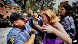 FILE— A University of Southern California protester, right, confronts a University Public Safety officer at the campus' Alumni Park during a pro-Palestinian occupation on April 24, 2024, in Los Angeles.