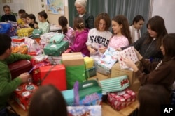 Bosnian children prepare presents for Ukrainian children at Safvet Beg Basagic elementary school in Sarajevo, Bosnia, Tuesday, Dec. 20, 2022. (AP Photo/Armin Durgut)