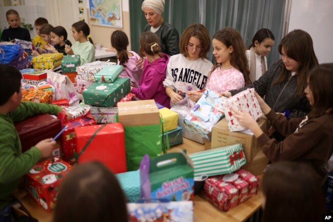 Bosnian children prepare presents for Ukrainian children at Safvet Beg Basagic elementary school in Sarajevo, Bosnia, Tuesday, Dec. 20, 2022. (AP Photo/Armin Durgut)