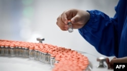 A staff member works during a media tour of a new factory built to produce a COVID-19 coronavirus vaccine at Sinovac, one of 11 Chinese companies approved to carry out clinical trials of potential coronavirus vaccines, in Beijing on September 24, 2020. (P