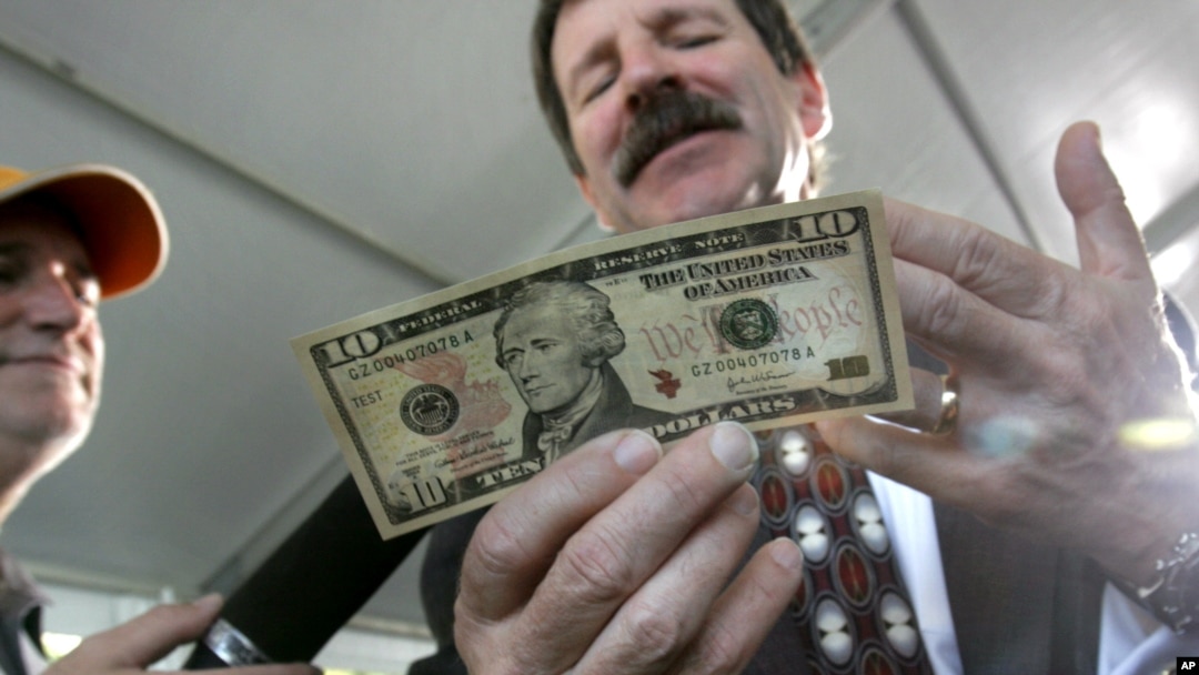 Thomas Ferguson, mantan direktur Bureau of Engraving and Printing, memegang lembaran $10.