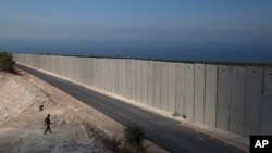 An Israeli soldier stands near a wall at the Israel Lebanon border near Rosh Haniqra, northern Israel, Sept. 5, 2018. Even with attention currently focused on Gaza-based Hamas militants along its southern border, Israel's most pressing security concerns lie to the north. 