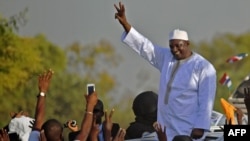 Gambia's new president Adama Barrow waves to supporters as he leaves the airport in Banjul, Jan. 26, 2017, after returning from Senegal.