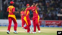 Zimbabwe players celebrate the dismissal of Pakistan's Ahmed Shahzad during a match at the Gaddafi Stadium in Lahore, Pakistan, Sunday, May 24, 2015. (AP Photo/B.K. Bangash)