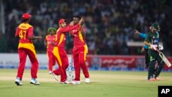 FILE: Zimbabwe players celebrate the dismissal of Pakistan's Ahmed Shahzad during a match at the Gaddafi Stadium in Lahore, Pakistan, Sunday, May 24, 2015. The Twenty20 matches Friday and Sunday mark a return of international cricket to Pakistan for the first time since gunmen attacked buses carrying the Sri Lankan cricket team and match officials in this eastern city six years ago. Security has been beefed up for the matches. (AP Photo/B.K. Bangash)