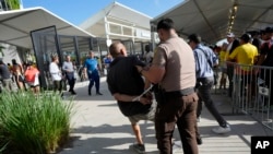 Un hombre es detenido por la policía afuera del estadio antes de la final de la Copa América entre Argentina y Colombia el domingo 14 de julio de 2024 en Miami Gardens, Florida, EEUU.