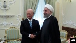 지난해 12월 이란 테헤란을 방문한 아마노 유키야 국제원자력기구(IAEA) 사무총장(왼쪽)이 하산 로하니 이란 대통령과 만나 악수하고 있다.