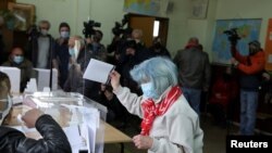 A woman casts her ballot at a polling station during the parliamentary election, in Sofia, Bulgaria, April 4, 2021.