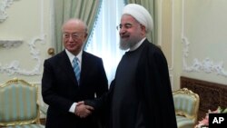 Presiden Iran Hassan Rouhani (kanan) menerima kunjungan Dirjen IAEA, Yukiya Amano dalam pertemuan di Teheran, Iran hari Minggu (18/12).