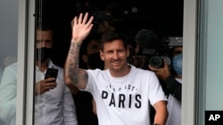 Lionel Messi saluda tras llegar al aropuerto Le Bourget, al norte de París, el martes 10 de agosto. 