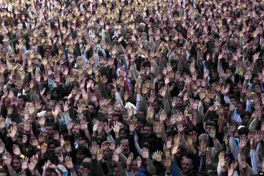 People raise their hands to condemn a suicide attack on Shi'ite mourners during a funeral in Rawalpindi, Pakistan, November 22, 2012. 