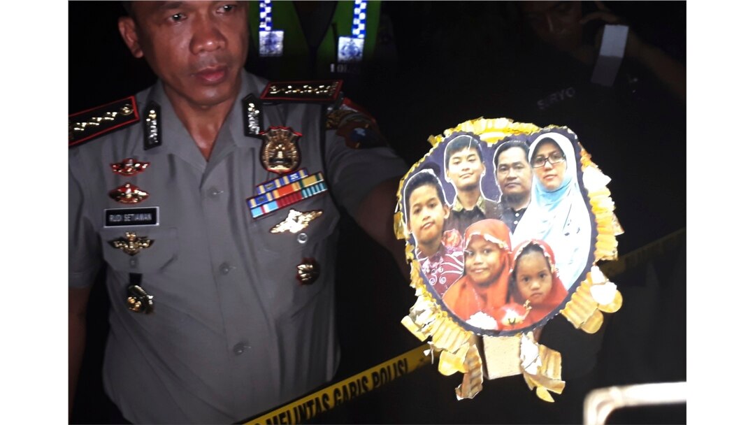 Polisi menunjukkan foto keluarga Dita Oepriarto, yang menjadi pelaku serangan bom terhadap sejumlah gereja di Surabaya, pada 13 Mei 2018. (Foto: AP)