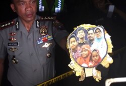 Polisi menunjukkan foto keluarga Dita Oepriarto, yang menjadi pelaku serangan bom terhadap sejumlah gereja di Surabaya, pada 13 Mei 2018. (Foto: AP)