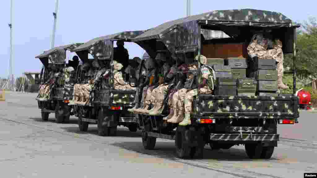 Nigerian soldiers sit in military trucks before leaving for Mali.