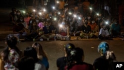 Residents flash the lights from their mobile phones during an anti-coup rally held despite an overnight curfew at the Myaynigone area of Sanchaung township in Yangon, Myanmar Monday, March 15, 2021. Myanmar's ruling junta has declared martial law in…