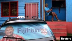 Poster pemilu menghiasi kaca belakang sebuah taksi di ibukota Suva, Fiji (26/8). (Reuters/Lincoln Feast)