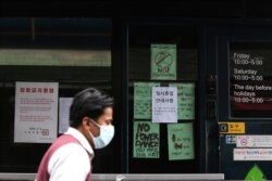 A man waring a face mask passes by the entrance of a temporary closed dance club in Seoul, South Korea, May 10, 2020.