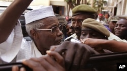 Former Chad dictator Hissène Habré, left, seen as he leaves the court in Dakar, Senegal, Nov. 25, 2005.