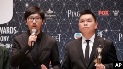 Hong Kong movie producer Andrew Choi, right, and director Ng Ka-leung pose after winning the Best Film award for their movie “Ten Years” during the Hong Kong Film Awards in Hong Kong, Sunday, April 3, 2016.