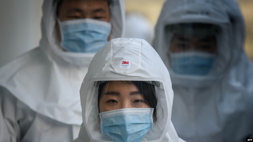 រូបឯកសារ៖ បុគ្គលិក​សុខាភិបាល​ពាក់​ម៉ាស​និង​សម្លៀក​បំពាក់​ការពារ​ការ​ឆ្លង​ជំងឺកូវីដ១៩ កំពុង​ដើរ​នៅ​សាកល​វិទ្យាល័យ Keimyung ក្រុង Daegu ប្រទេស​កូរ៉េ​ខាង​ត្បូង កាល​ពី​ថ្ងៃ​ទី​១២​ មីនា ២០២០។