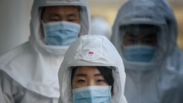In this photo taken on March 12, 2020, medical workers wearing protective clothing against the COVID-19 novel coronavirus walk to a decontamination area at the Keimyung University hospital in Daegu. - South Korea.