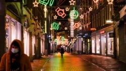 خیابانی در آمستردام با تزئینات کریسمس که اصولاً در این فصل پر از مردم و خریدار بود خالی است. دولت هلند محدودیت‌های سفت و سخت‌تری پس از کشف گونه امیکرون در این کشور اعمال کرده است - ۸ آذر ۱۴۰۰
