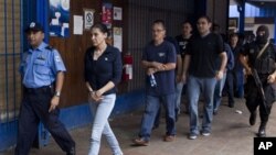 Warga Meksiko yang diduga anggota kelompok kejahatan terorganisasi dan telah menyamar sebagai jurnalis dikawal polisi ke pengadilan (19/12). (AP/Esteban Felix)