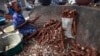 FILE: A woman peels cassava to make cassava flour in a market in Lagos, Nigeria, May 2013.