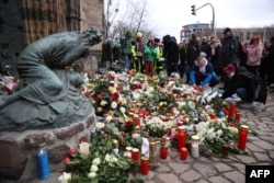 People lay flowers and candles at the site of a car-ramming attack on a Christmas market in Magdeburg, Germany, on Dec. 21, 2024.