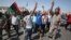 Libyans hold up their ink-marked fingers that shows they have voted as they celebrate in Martyrs' Square in Tripoli, July 7, 2012. 