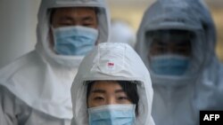 In this photo taken on March 12, 2020, medical workers wearing protective clothing against the COVID-19 novel coronavirus walk to a decontamination area at the Keimyung University hospital in Daegu. - South Korea -- once the largest coronavirus outbreak o