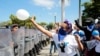 ARCHIVO - Un manifestante lanza un globo a la policía antidisturbios durante la conmemoración del Día Internacional de los Derechos Humanos en Managua, Nicaragua, el 10 de diciembre de 2019.