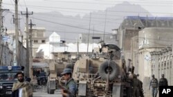 Afghan and NATO forces secure the entrance of the police headquarters after a Taliban suicide attack killed the police chief of southern Afghanistan's Kandahar province, April 15, 2011