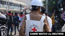 FILE - A Red Cross worker is seen amid protesters against the military coup, in Dawei, Myanmar, Feb. 28, 2021, in this photo obtained from social media. (Dawei Watch/via Reuters) 