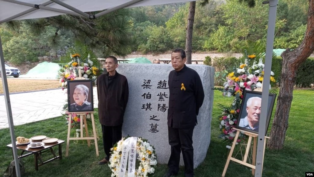 2019年10月18日,赵紫阳夫妇墓碑前摆放着出席骨灰安葬仪式的亲友们献的鲜花。赵紫阳之子赵二军(右)立于碑前。(美国之音艾伦拍摄)