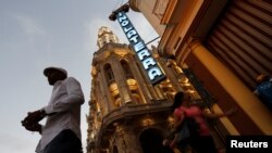 A neon sign shines above the entrance of the Hotel Inglaterra in Havana, Cuba, Feb. 13, 2018. 