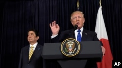 Presiden AS, Donald Trump, berbicara dengan PM Jepang, Shinzo Abe, yang menyimak saat mereka berdua mengeluarkan pernyataan terkait Korea Utara di Mar-a-Lago (11/2). Palm Beach, Florida, AS. (foto: AP Photo/Susan Walsh).