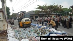 Satuan Pamong Praja Kabupaten Sleman memusnahkan berbagai macam minuman keras hasil operasi beberapa waktu lalu, namun tidak bisa menghentikan konsumsi oplosan. (VOA/Nurhadi)