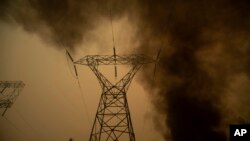 Smoke billows around power transmission lines as the "Camp Fire" burns in Big Bend, California, Nov. 9, 2018.