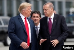 FILE - U.S. President Donald Trump and Turkish President Recep Tayyip Erdogan converse at the start of a NATO summit in Brussels, Belgium, July 11, 2018.