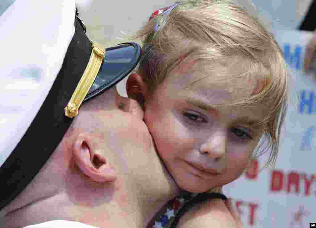 Five-year-old Adley Lausch, cries as she gets a kiss from her father, Lt., Adam Lausch, after he disembarked from the nuclear powered aircraft carrier USS Harry S. Truman at Norfolk Naval Station in Norfolk, Virginia, July 13, 2016.