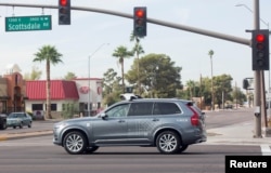 FILE -A self-driving Volvo vehicle, purchased by Uber, moves through an intersection in Scottsdale, Arizona, Dec. 1, 2017.