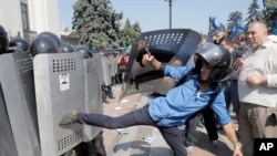 Ukrainian protesters clash with riot police after a vote to give greater powers to the east, outside the Parliament, Kyiv, Ukraine, Aug. 31, 2015.