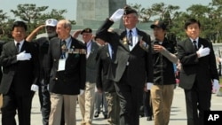 US veterans leave South Korea's national cemetery in Seoul after paying tribute to their colleagues killed during the Korean War, 23 June 2010