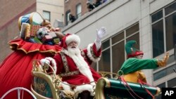 Deda Mraz maše sa svoje kočije za vreme parade na Dan zahvalnosti u Njujorku, 25. novembra 2021. 