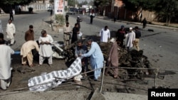 Police and rescue officials cover a body after a blast in Quetta, Pakistan, June 23, 2017. 